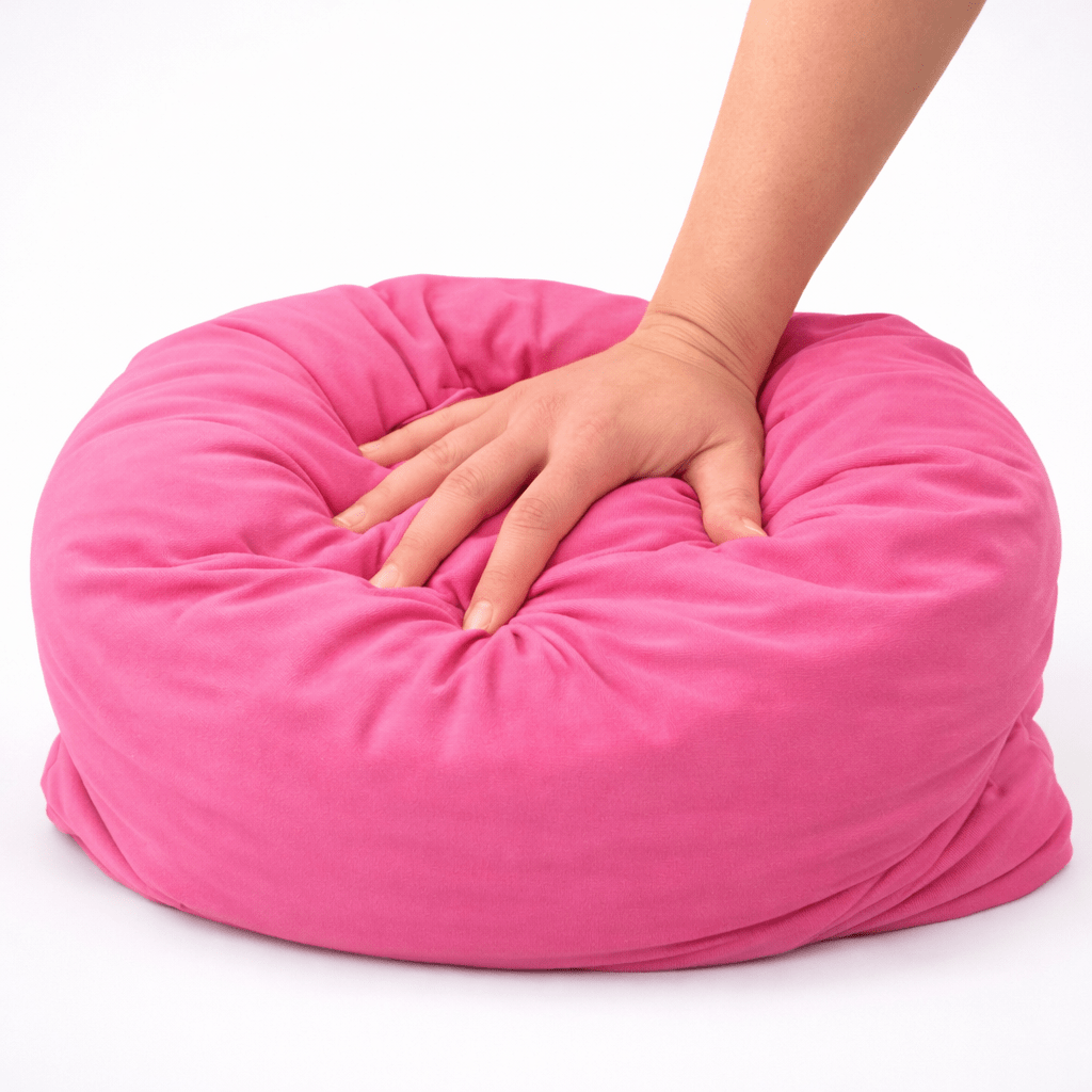 Hand pressing hot pink breakup pillow showing ultra soft squishy bamboo fabric comfort.