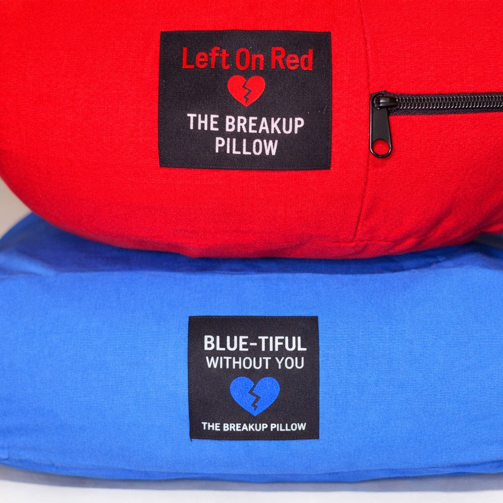 Red and blue breakup pillow labels with 'Left On Red' and 'Blue-tiful Without You' written on them.