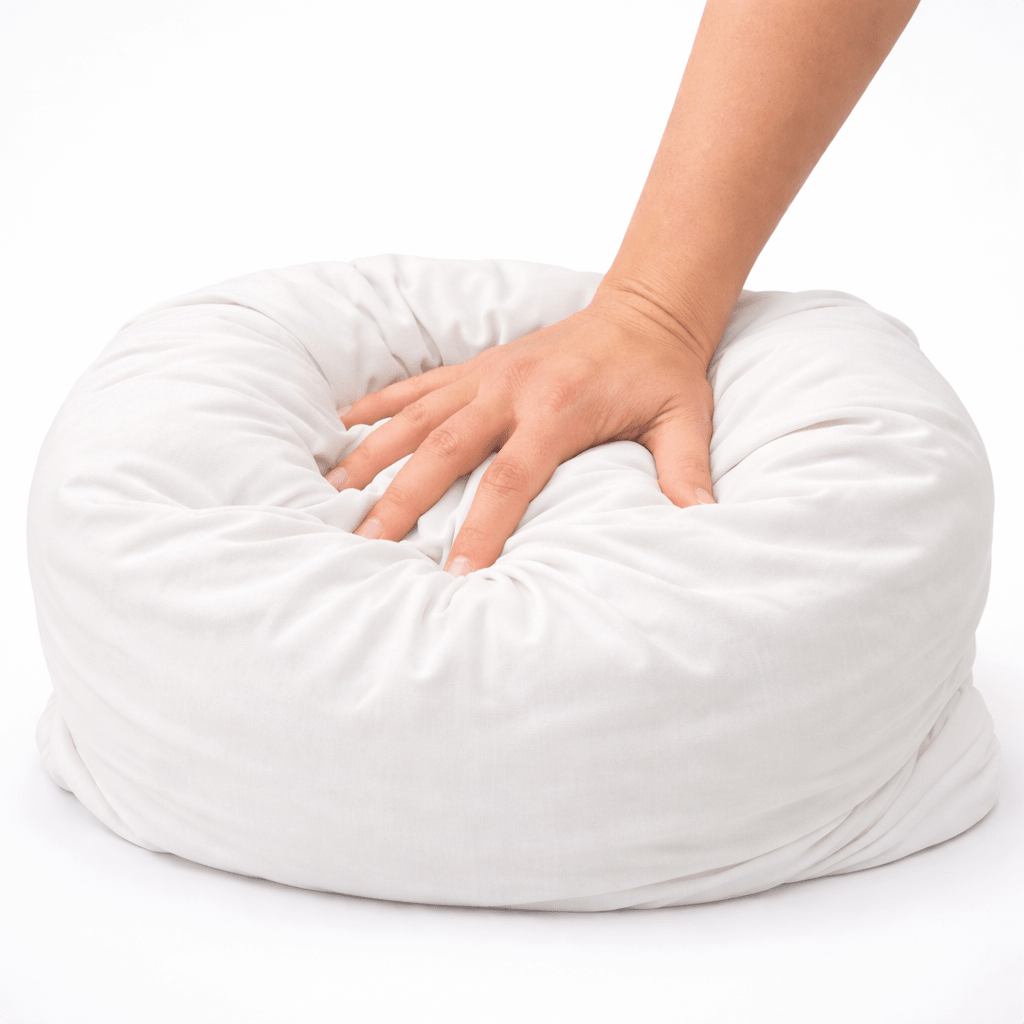 Image of hand compressing a squishy and soft white breakup pillow.